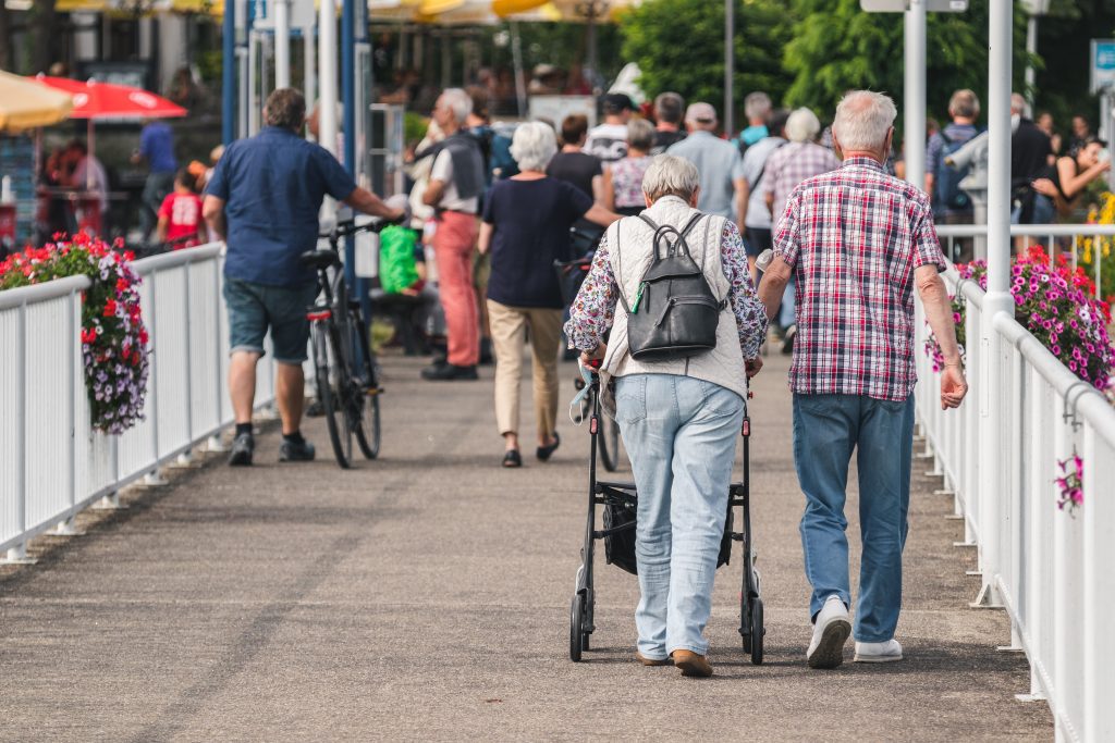 An elderly couple walking in a neighborhood.
